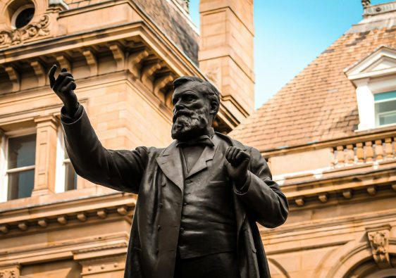 Bronze statue of W.E. Forster in front of historic architecture in Bradford, England. filming locations