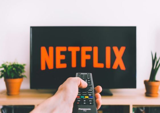 person holding remote pointing at TV