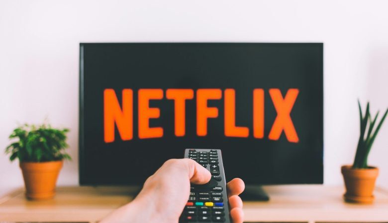 person holding remote pointing at TV